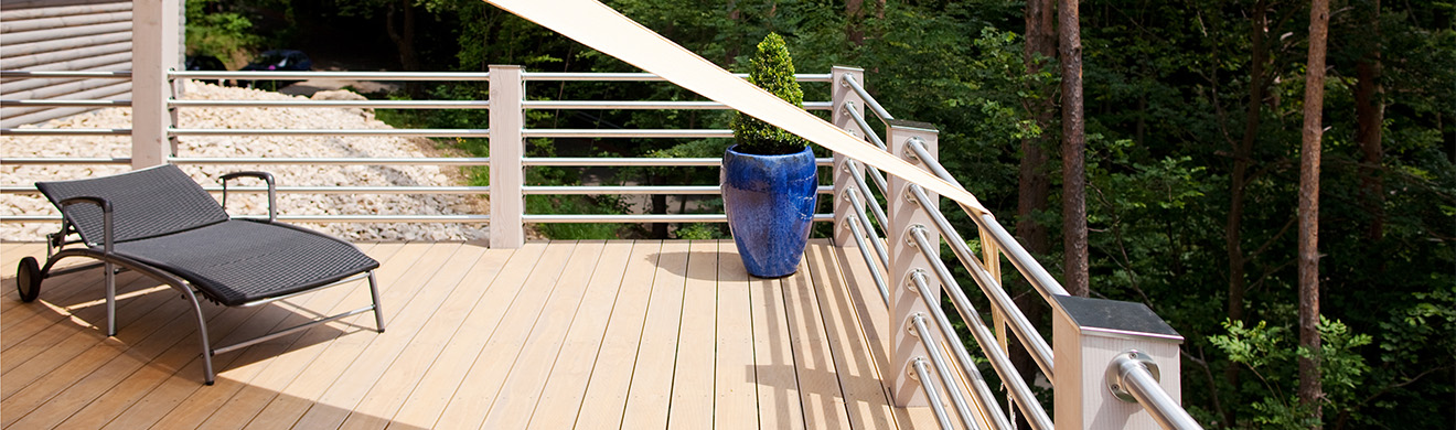 Sonnige Terrasse im Wald mit Holzgeländer und freiem Ausblick, ideal zur Inspiration für Balkonsanierung in Wetter.