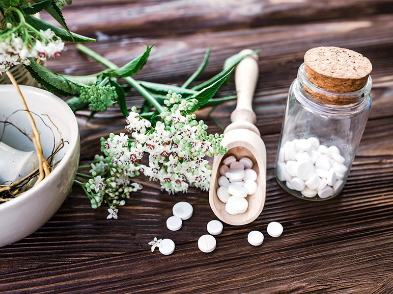 Baldrianwurzel Tabletten und -Extrakt auf Holztisch, pflanzliche Schlafhilfe zum Baldrian kaufen in Herdecke, beruhigend und entspannend.