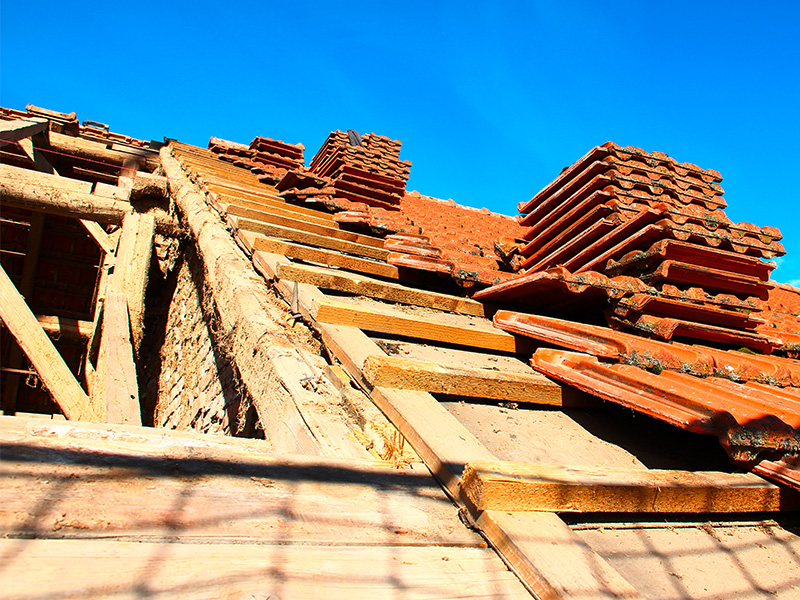 Alter Dachstuhl mit freiliegenden Balken und beschädigten Dachziegeln während einer Dachsanierung in Hagen.