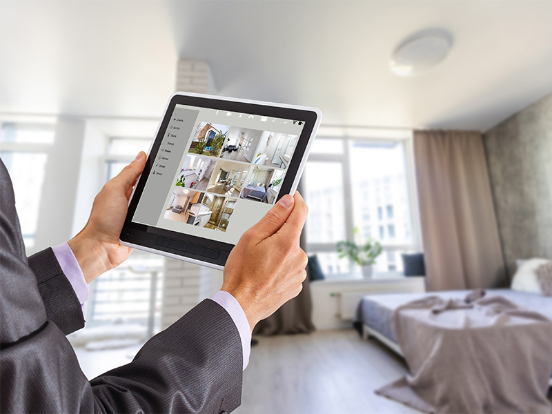 Elektriker in Hagen im modernen Zuhause steuert Smart Home Systeme über Tablet Benutzeroberfläche für Licht, Klima und Sicherheit.