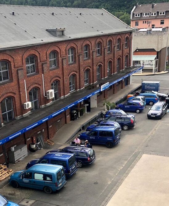Firmengebäude von Brennecke Cleaning in Hagen mit geparkten Reinigungsfahrzeugen, symbolisiert professionelle Gebäudereinigung und Servicebereitschaft.