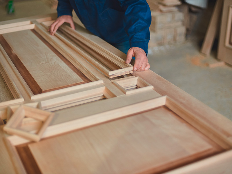 Handwerker fertigt handgefertigte Holztüren in Hagen aus hochwertigem Holz, präzise bearbeitet in traditioneller Tischlerwerkstatt.“