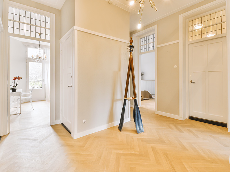 Helles Wohnzimmer mit Holzinnentüren in Hagen, Holzfußboden und weißer Wandgestaltung, stilvoller Übergang zum angrenzenden Raum.“