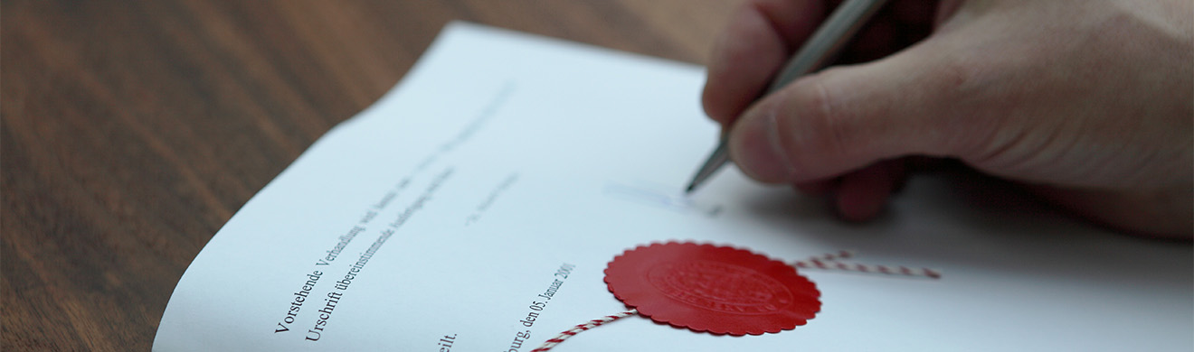 Notar in Gevelsberg beglaubigt die Vertragsunterzeichnung eines Paares in einem modernen Büro, rechtliche Sicherheit garantiert.