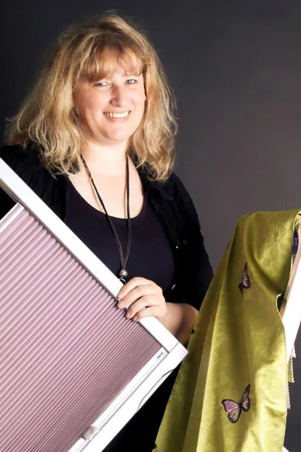 Relindis Gerleve-Buchna hält elegantes Plissee Rollo, zeigt farbige Stoffauswahl – Angebot zum „Plissee kaufen in Hagen“.