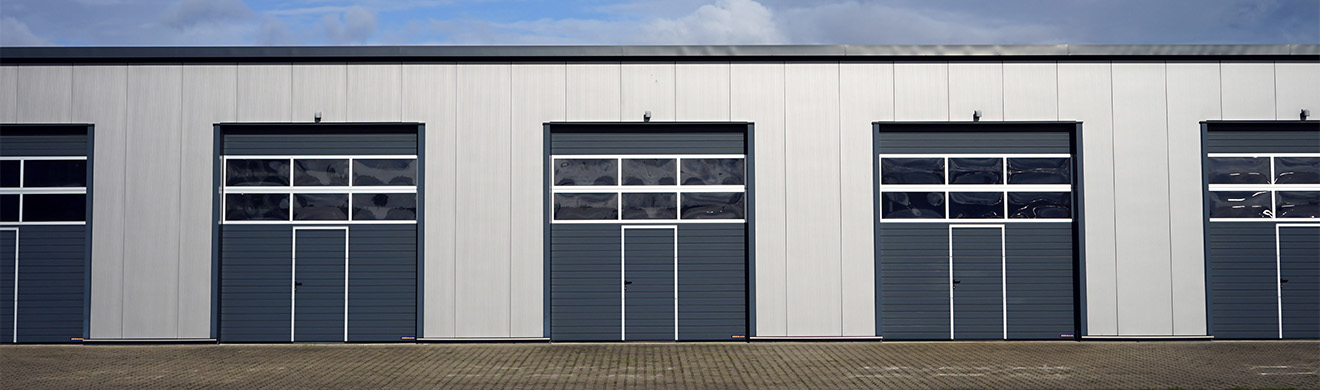 Modernes Gewerbegebäude mit großem Sektionaltor, robust und funktional, ideal für Industrie  und Betriebsflächen mit effizientem Torzugang.