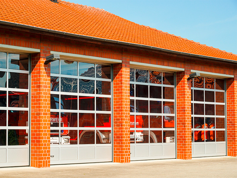 Modernes Feuerwehrgerätehaus mit geöffneten Sektionaltoren in Hagen, zeigt sichere und praktische Torlösungen für Gewerbe und Einsatzfahrzeuge.