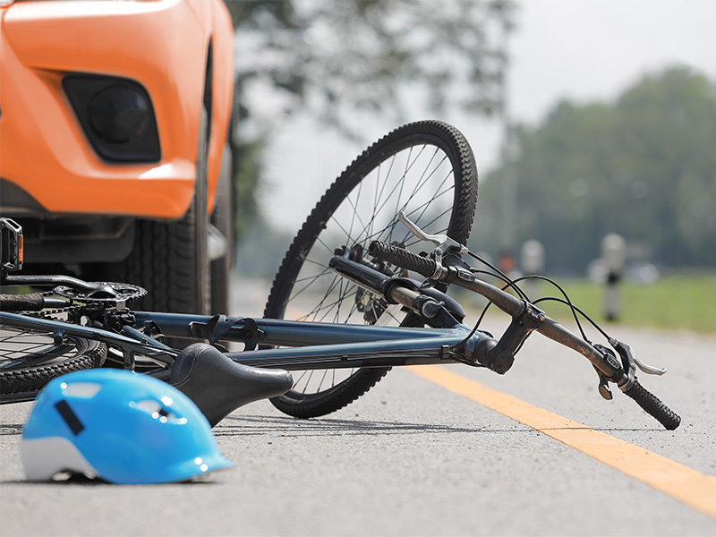 Auto und Fahrrad nach einem Zusammenstoß auf der Straße, passend zum Thema Schadensregulierung nach Verkehrsunfall.