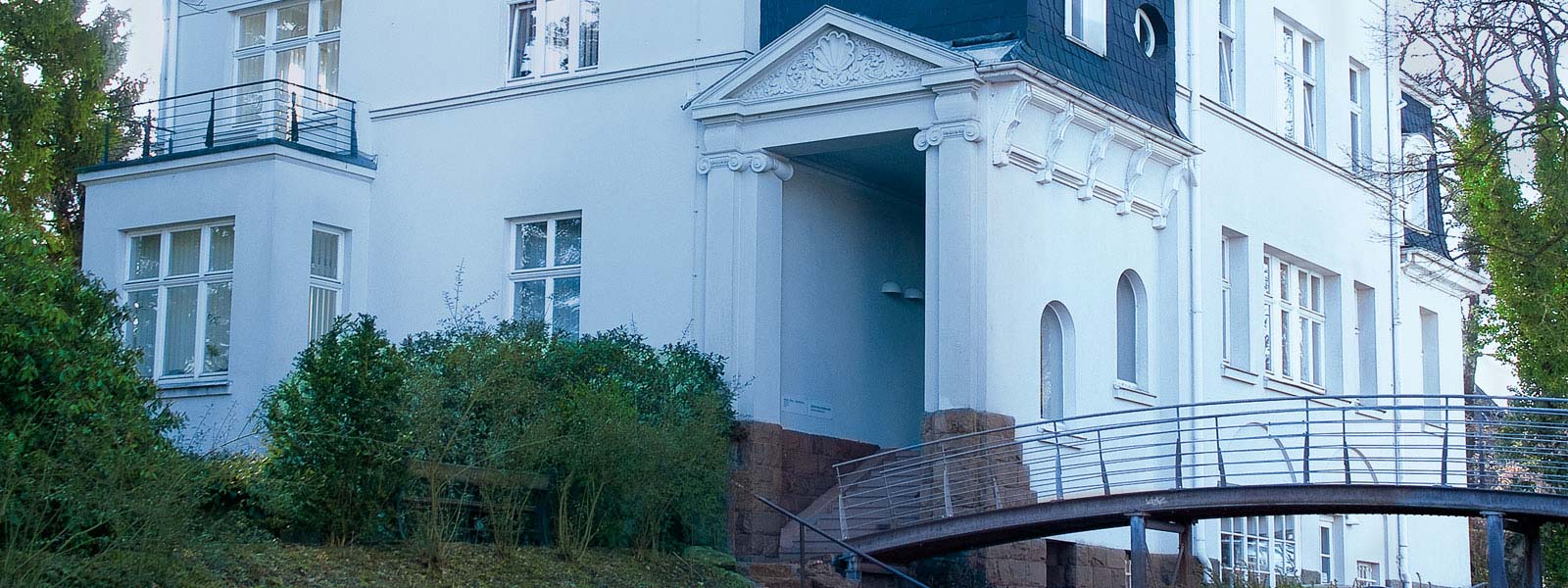 Außenansicht der FRIEBE – PRINZ + PARTNER mbB Kanzlei mit Eingang und Firmenzeichen vor dem Bürogebäude in Lüdenscheid.